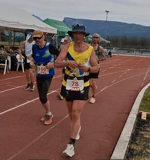 Coureurs en action sur une piste synthétique lors d'une compétition, dossard 78 visible