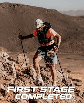 Coureur gravissant une dune rocheuse lors du Marathon des Sables